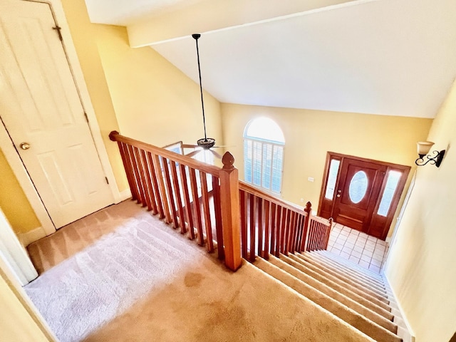 staircase featuring carpet, high vaulted ceiling, and beam ceiling