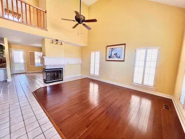 unfurnished living room with baseboards, visible vents, a fireplace, and light wood finished floors