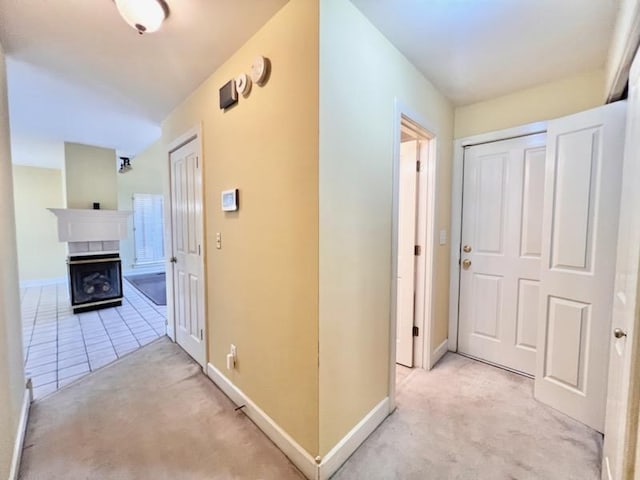hall featuring light colored carpet and baseboards
