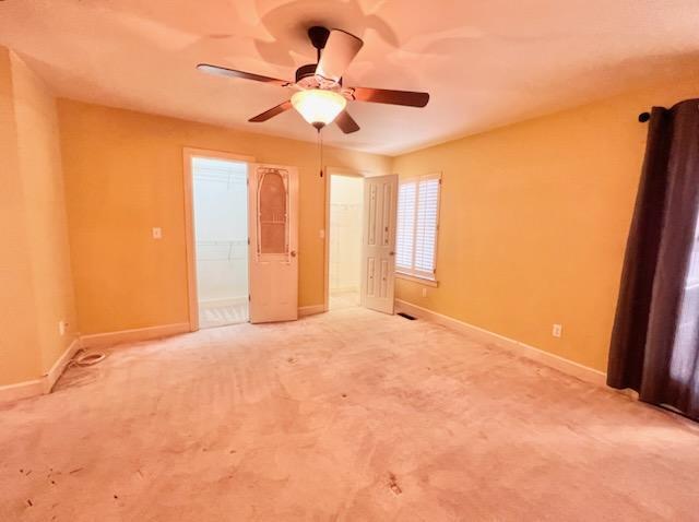 unfurnished bedroom with a ceiling fan, baseboards, and carpet flooring
