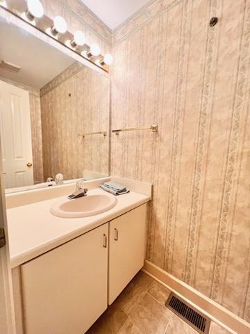 bathroom featuring ornamental molding, tile patterned flooring, visible vents, and vanity
