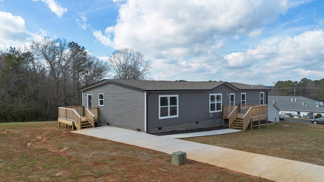 manufactured / mobile home with a wooden deck and a front yard