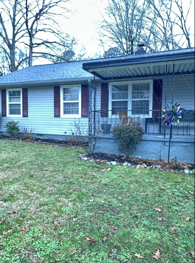 ranch-style house with a porch and a front lawn