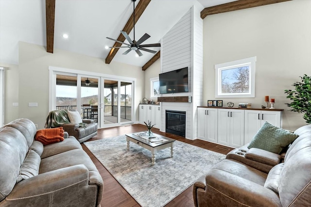 living room with a fireplace, ceiling fan, dark hardwood / wood-style flooring, and beam ceiling