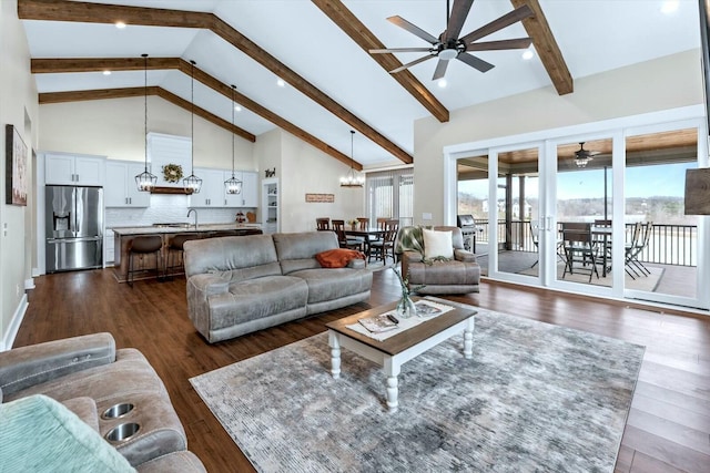 living room with sink, beamed ceiling, ceiling fan with notable chandelier, dark hardwood / wood-style flooring, and high vaulted ceiling