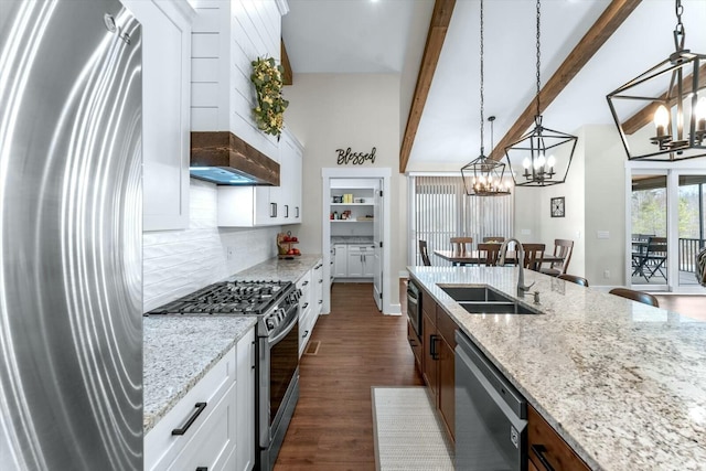 kitchen with sink, white cabinetry, stainless steel appliances, hanging light fixtures, and light stone countertops