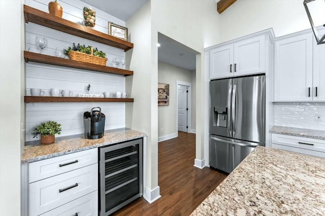 kitchen with white cabinetry, beverage cooler, stainless steel refrigerator with ice dispenser, and light stone counters