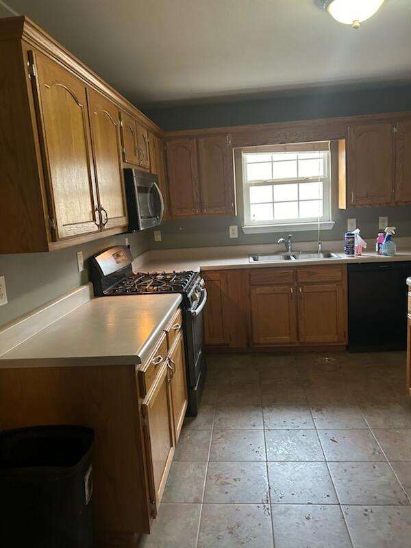 kitchen with light tile patterned floors, sink, and stainless steel appliances