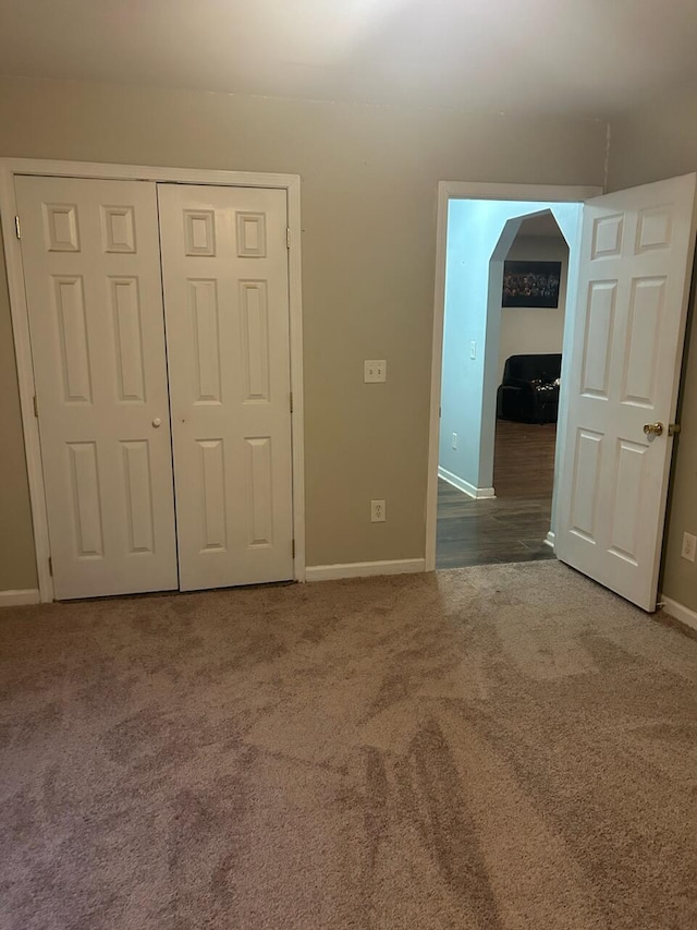 unfurnished bedroom featuring carpet and a closet