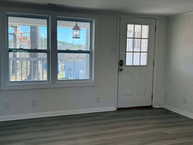 entryway with visible vents, baseboards, dark wood-type flooring, and ornamental molding