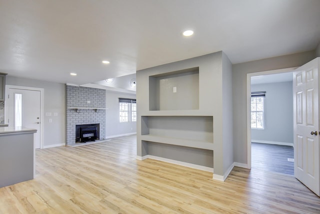 unfurnished living room with a fireplace and light wood-type flooring