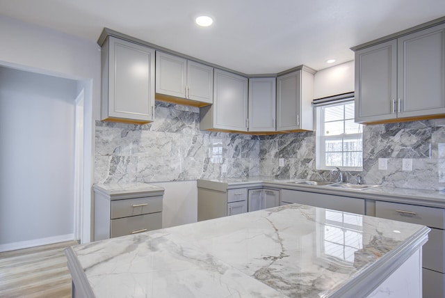 kitchen featuring sink, tasteful backsplash, and gray cabinetry