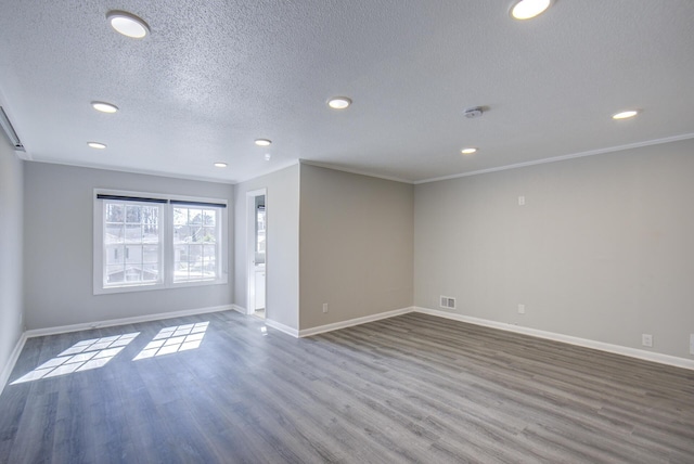 spare room with a textured ceiling, ornamental molding, and hardwood / wood-style flooring