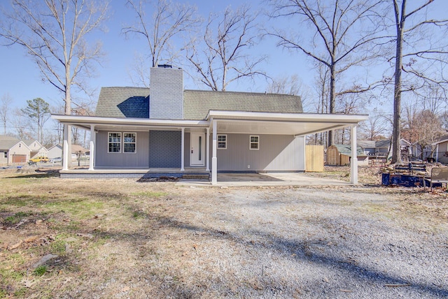 back of property with a carport and a porch