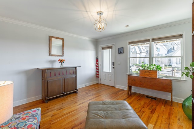 foyer entrance with visible vents, baseboards, light wood-style floors, and crown molding