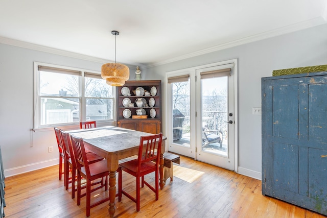 dining room featuring a wealth of natural light, light wood-style flooring, and ornamental molding