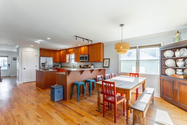 dining room featuring light wood-type flooring, baseboards, and crown molding