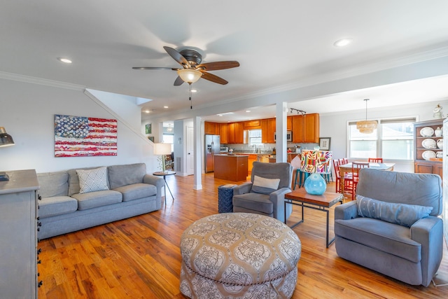 living room with recessed lighting, light wood-type flooring, ceiling fan, and ornamental molding