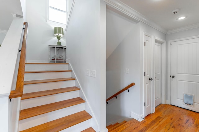 stairway with crown molding, recessed lighting, wood finished floors, and baseboards