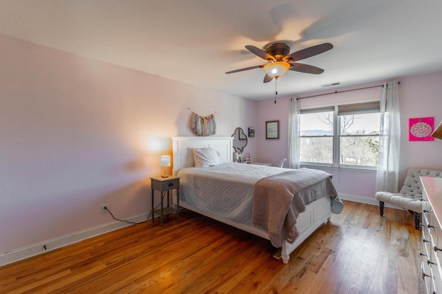 bedroom with a ceiling fan, baseboards, visible vents, and light wood finished floors