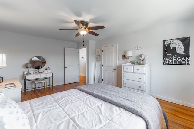 bedroom with ceiling fan, baseboards, and wood finished floors