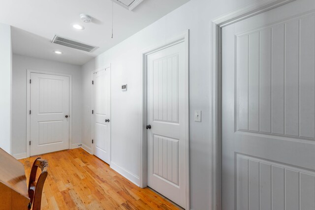 corridor with light wood-style flooring, recessed lighting, baseboards, and visible vents