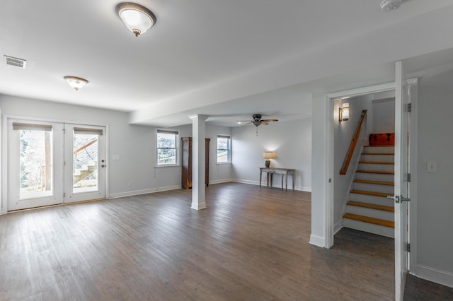 basement featuring ceiling fan, visible vents, dark wood finished floors, and stairs