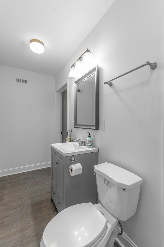 half bath with toilet, baseboards, and visible vents