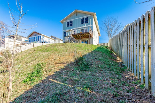 back of property featuring a deck and a fenced backyard