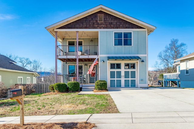 view of front of property featuring a balcony, board and batten siding, covered porch, and a front lawn