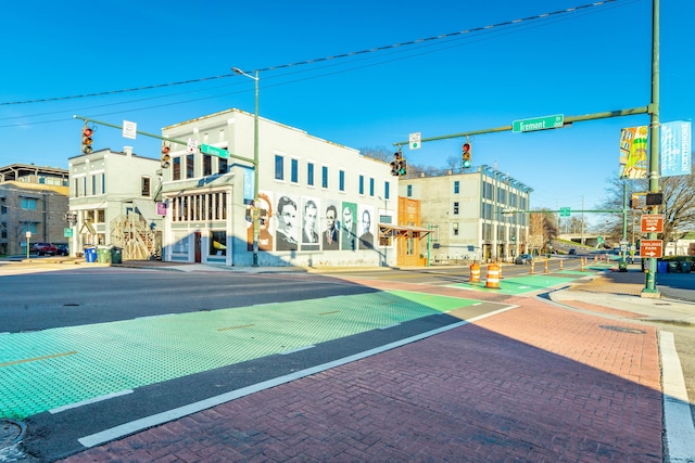 view of road with sidewalks, curbs, street lights, and traffic lights