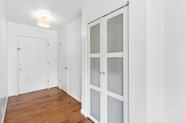 hallway featuring baseboards and wood finished floors