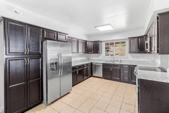 kitchen featuring dark brown cabinetry, appliances with stainless steel finishes, light countertops, a sink, and light tile patterned flooring