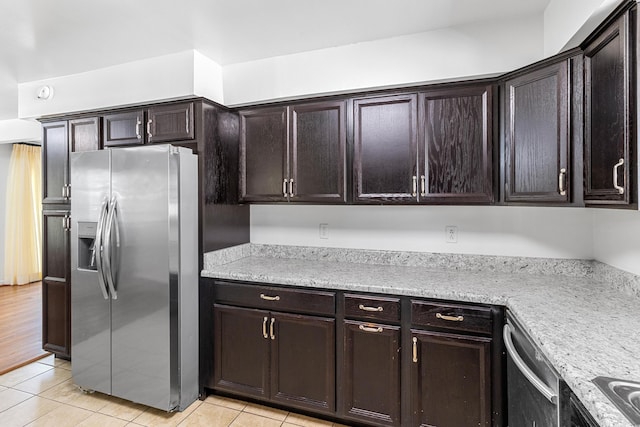 kitchen with appliances with stainless steel finishes, light tile patterned flooring, and dark brown cabinets