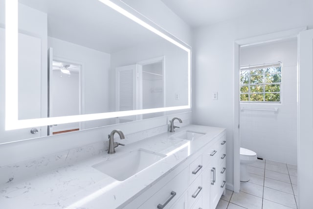 full bathroom with toilet, tile patterned flooring, double vanity, and a sink