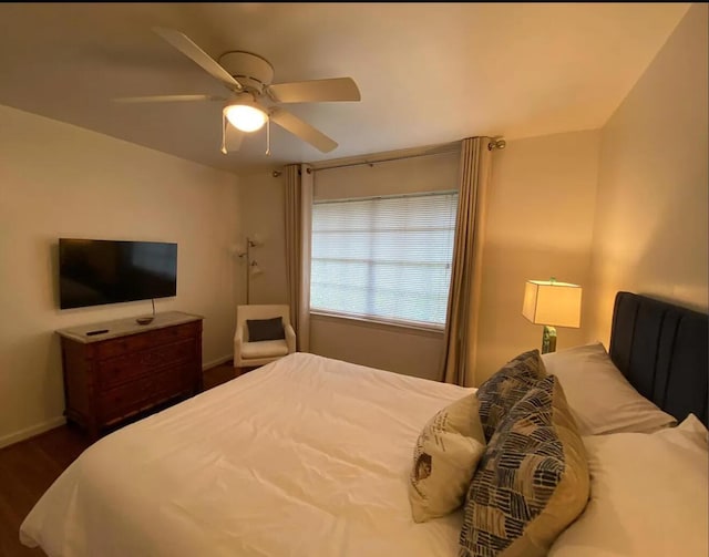 bedroom featuring ceiling fan, dark wood-type flooring, and baseboards