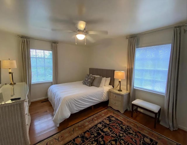 bedroom featuring ceiling fan, baseboards, and wood finished floors