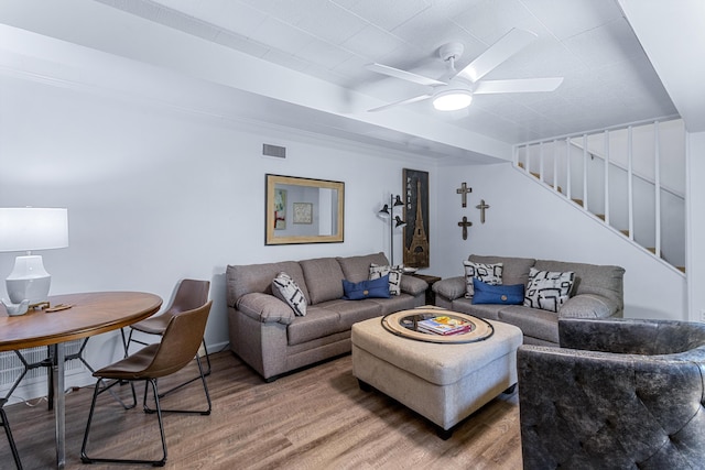 living room featuring stairs, ceiling fan, wood finished floors, and visible vents