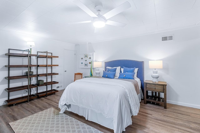 bedroom featuring baseboards, crown molding, visible vents, and dark wood-type flooring