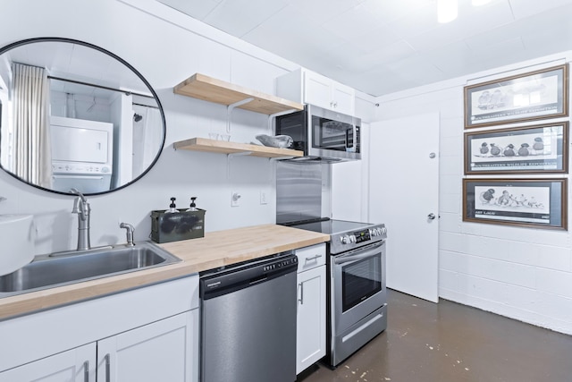 kitchen with stacked washer / dryer, wood counters, stainless steel appliances, white cabinetry, and open shelves