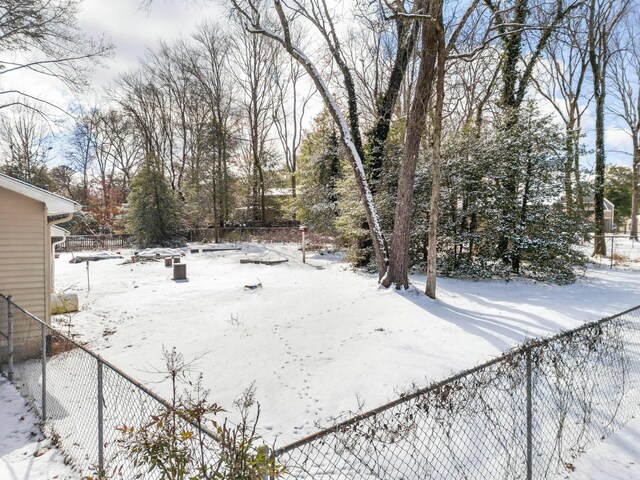 snowy yard featuring fence