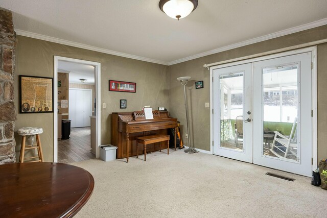 living area featuring ornamental molding, french doors, visible vents, and light colored carpet