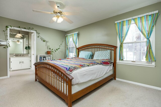 bedroom with baseboards, light colored carpet, ceiling fan, a textured ceiling, and a sink