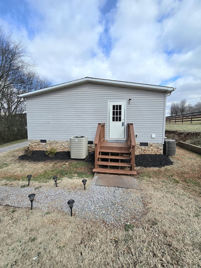 exterior space with crawl space, fence, and central AC unit