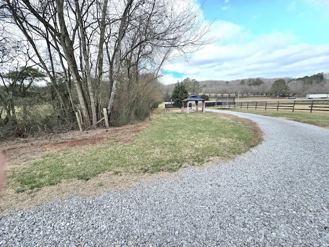 view of yard featuring driveway and fence