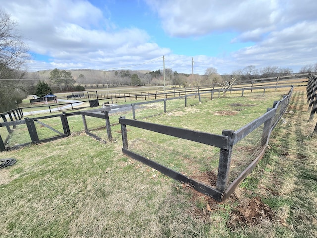 view of yard with a rural view and fence