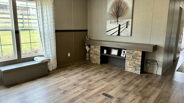 unfurnished living room featuring wood finished floors and visible vents