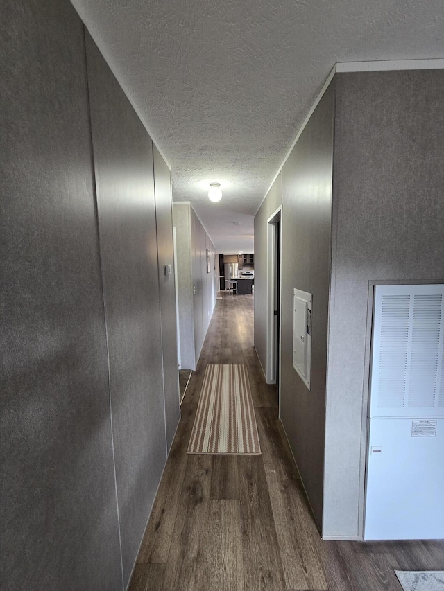 hall with dark wood finished floors and a textured ceiling