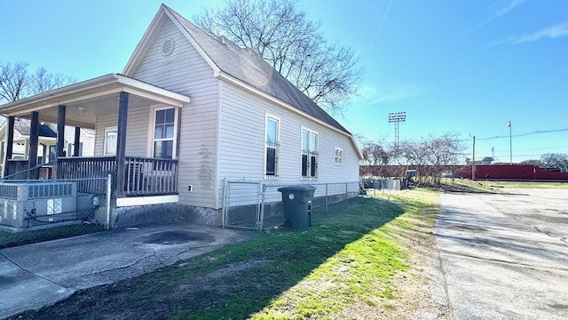 view of home's exterior featuring a porch and fence