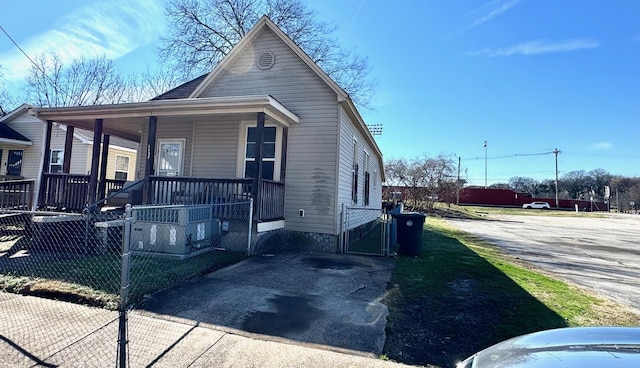 view of front of home featuring covered porch, driveway, fence, and a gate